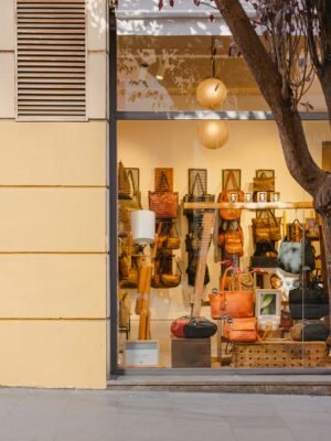 Elegant handbag store display in Barcelona, featuring a variety of stylish bags through a large glass window.