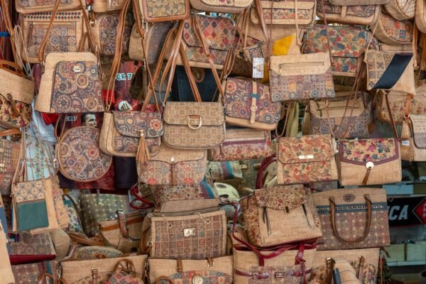 Vibrant selection of handmade patterned bags showcasing intricate designs at a local market.